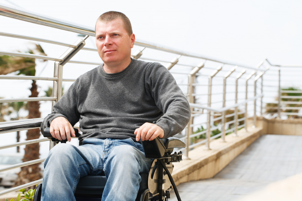 Man in a wheelchair sits close to railings.