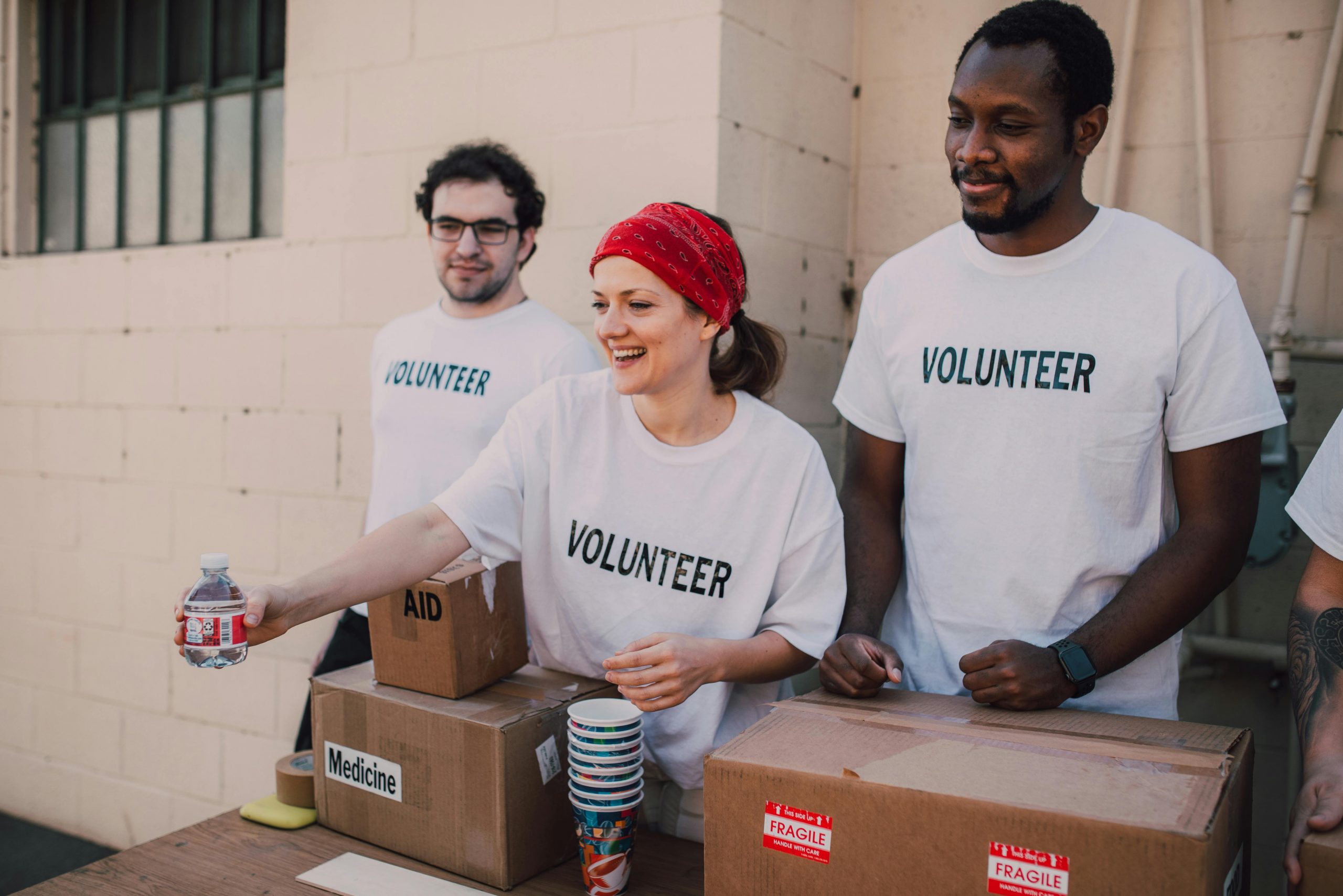 three volunteers donating goods