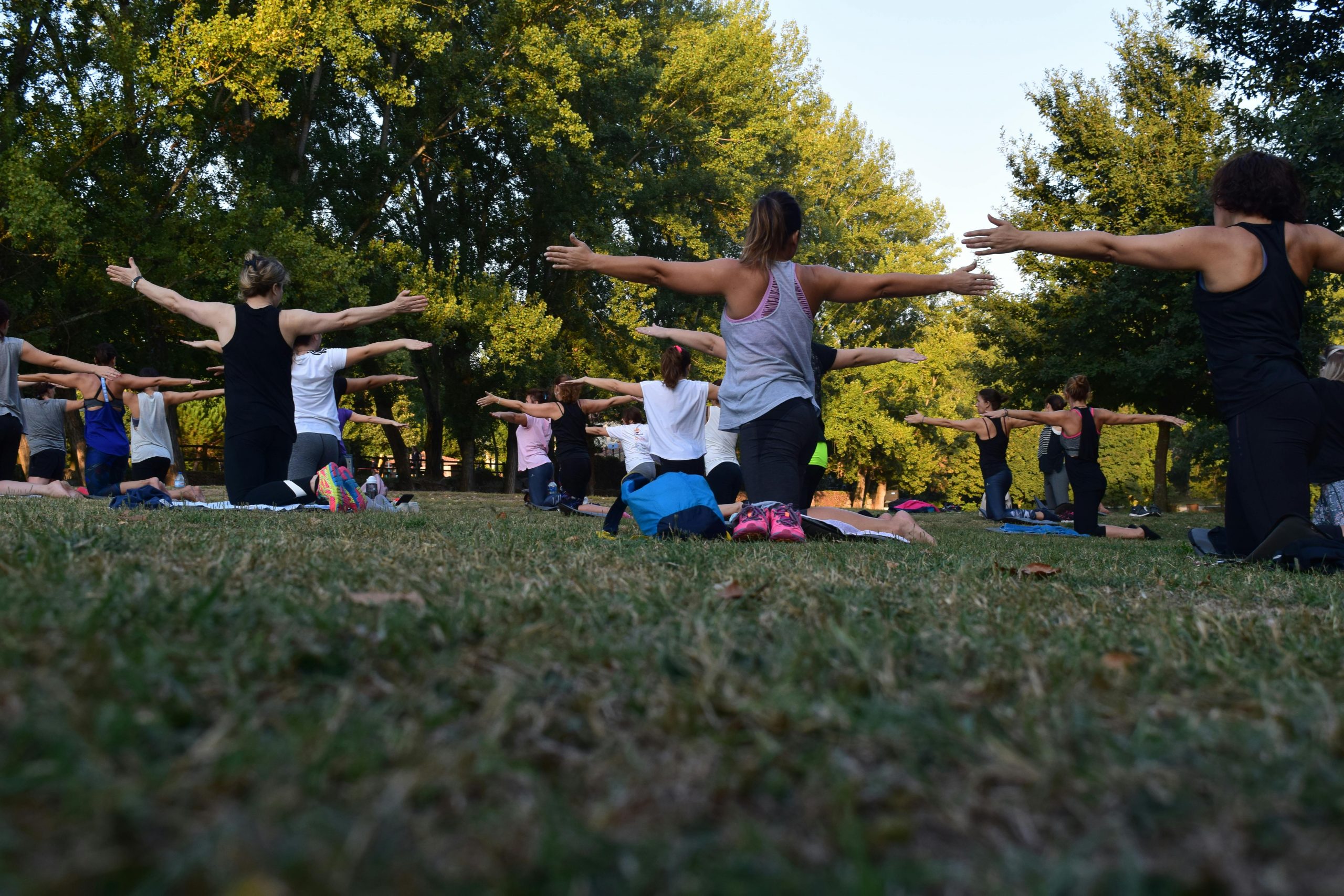 large group of women doing yoga outdoors
