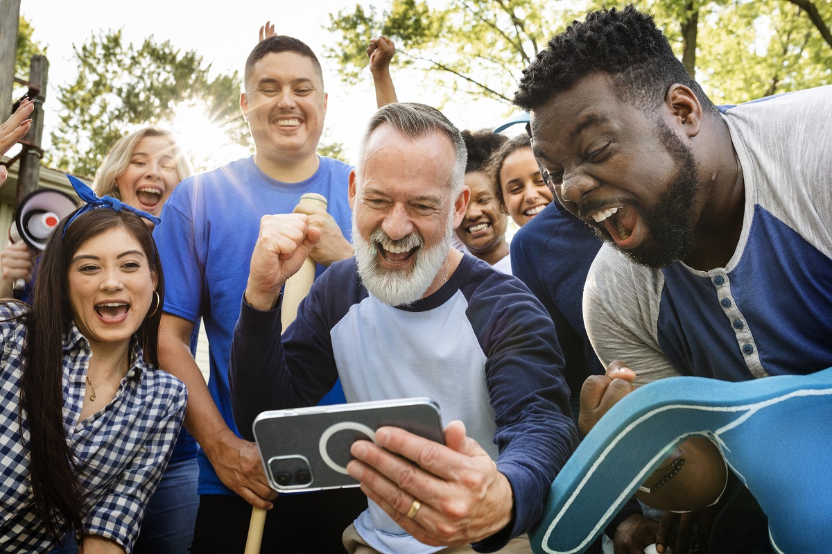 diverse community members watching on a phone happily